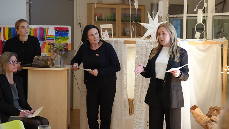 En kvinna talar framför publik.